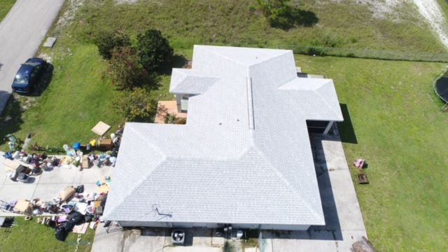An aerial view of a house with a white roof.