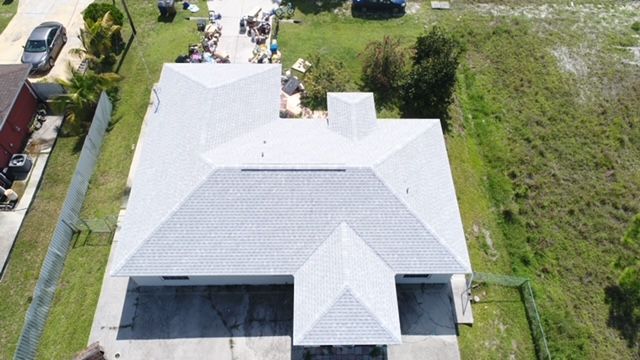 An aerial view of a house with a white roof.