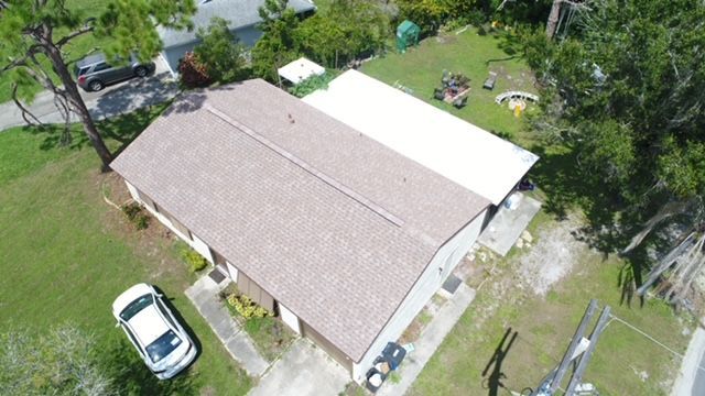 An aerial view of a house with a car parked in front of it.