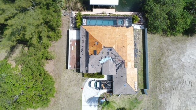 An aerial view of a house with a pool and a car parked in front of it.