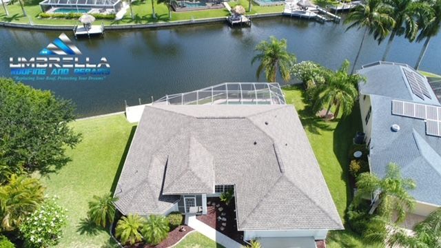 An aerial view of a house next to a body of water