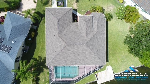 An aerial view of a house with a roof and a pool.