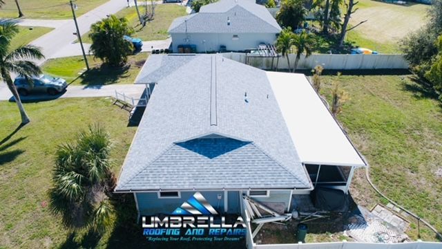 An aerial view of a house with a logo for umbrella roofing and repair
