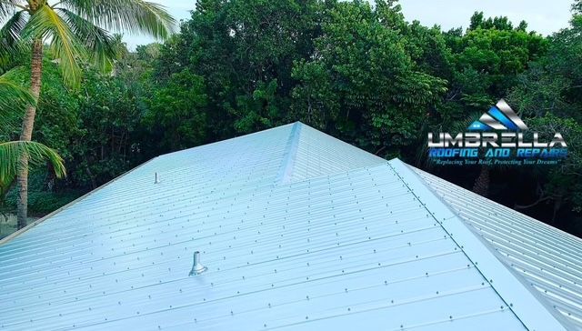 A roof with a umbrella logo on it is surrounded by trees.