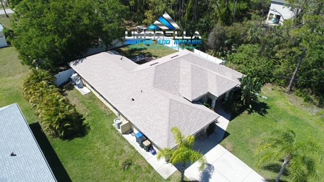 An aerial view of a house with a gray roof