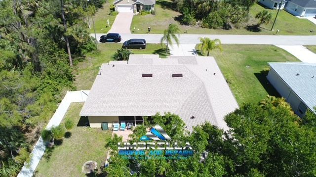 An aerial view of a house with a pool in the backyard