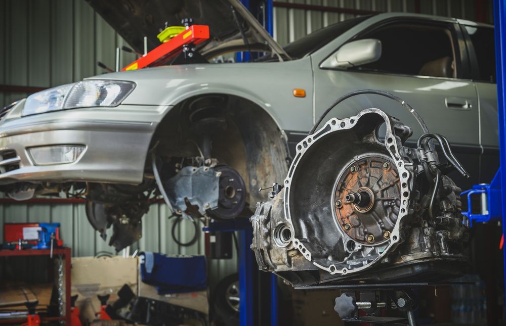 Car on A Lift in A Garage with Transmission Removed, Exposing Engine Components — AutoHop Lambton in Lambton, NSW