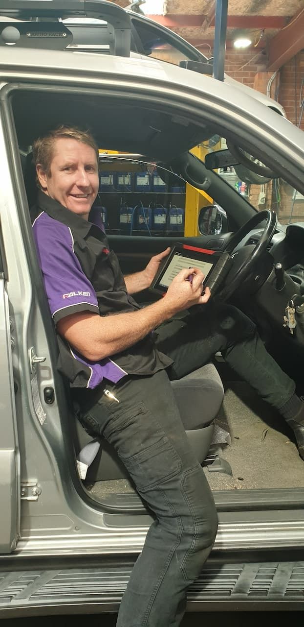 A Man in A Vehicle, Smiling Doing Rego Checks — AutoHop Lambton in Lambton, NSW