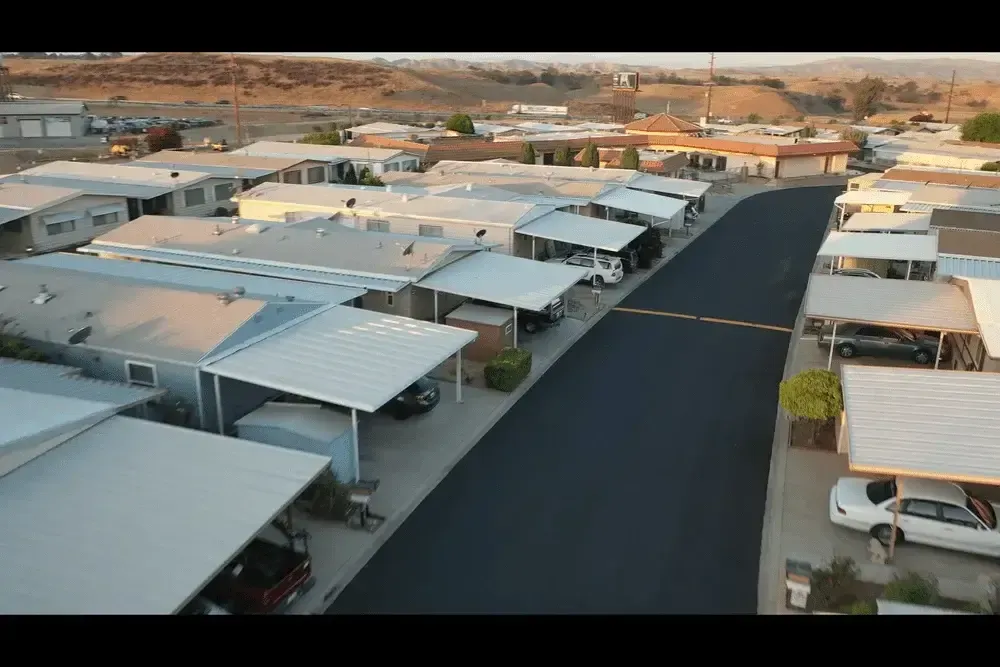 An aerial view of a mobile home park with cars parked on the side of the road