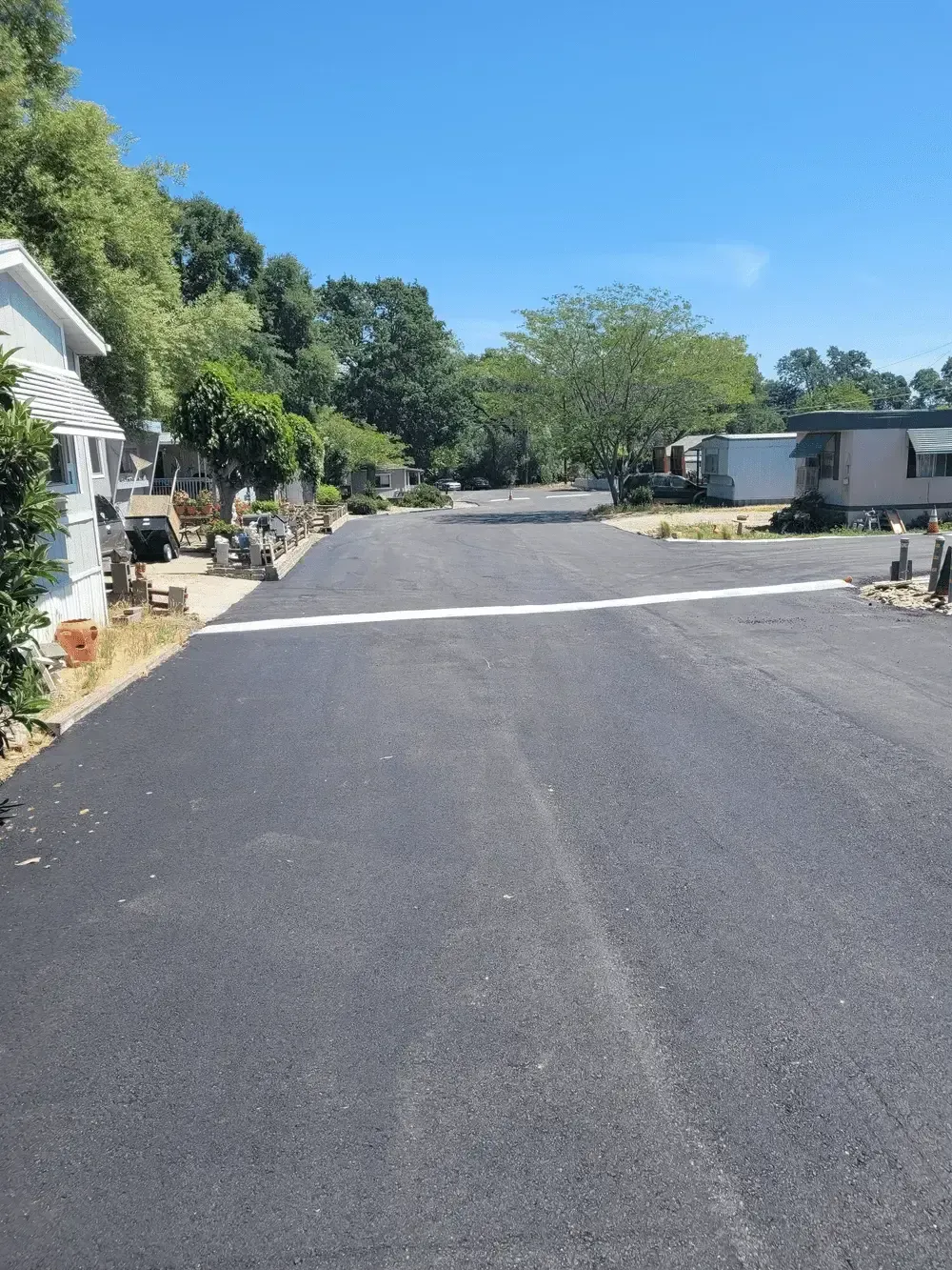 A road with a white line on it in a mobile home park.