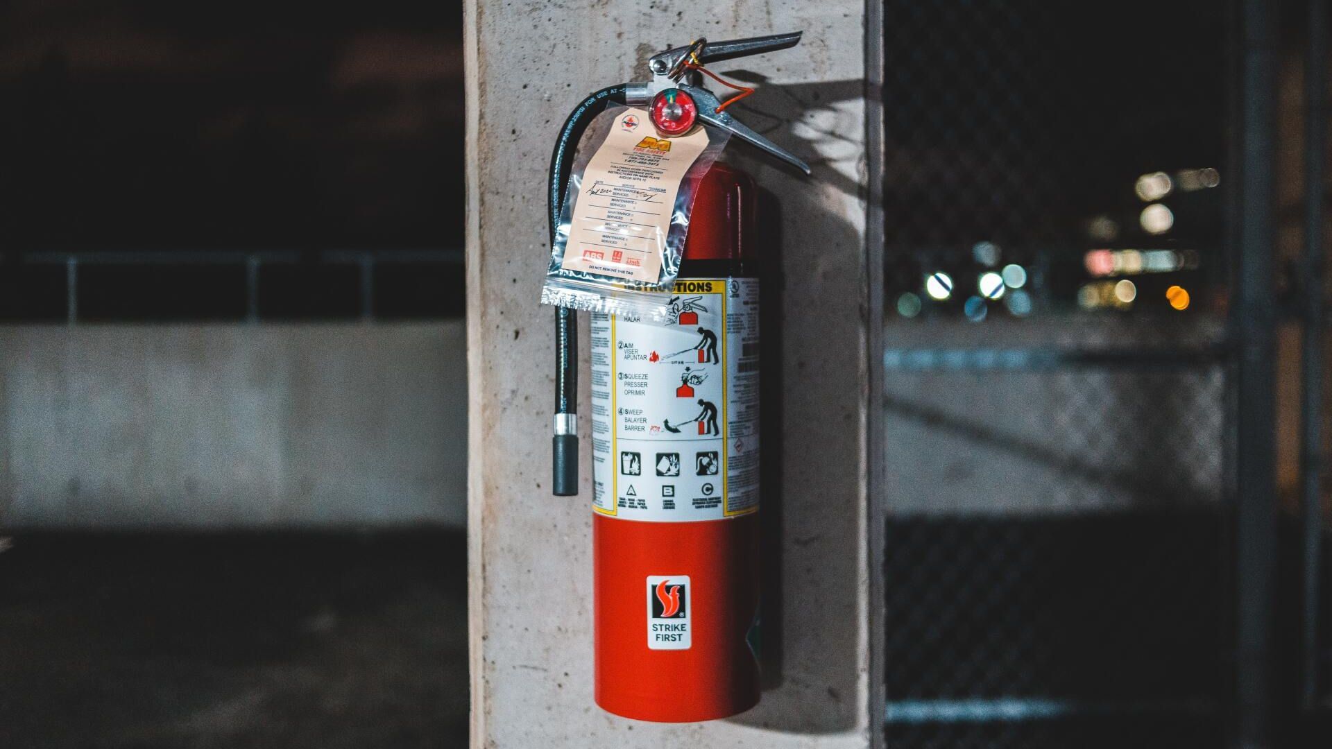 A fire extinguisher on a wall. Photo by Erik Mclean on Unsplash.