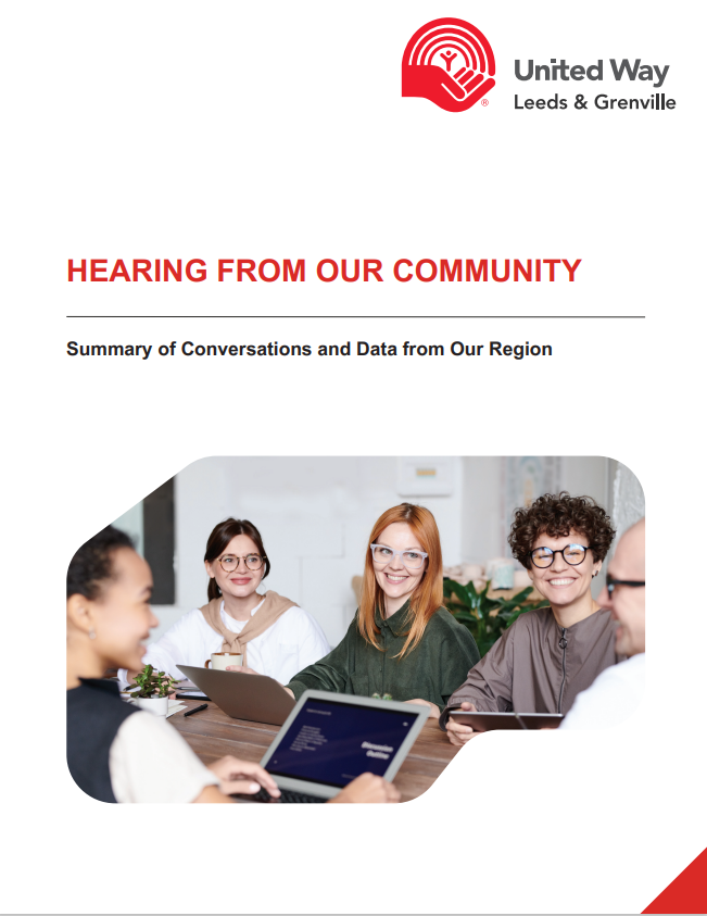 A group of people are sitting around a table with laptops.