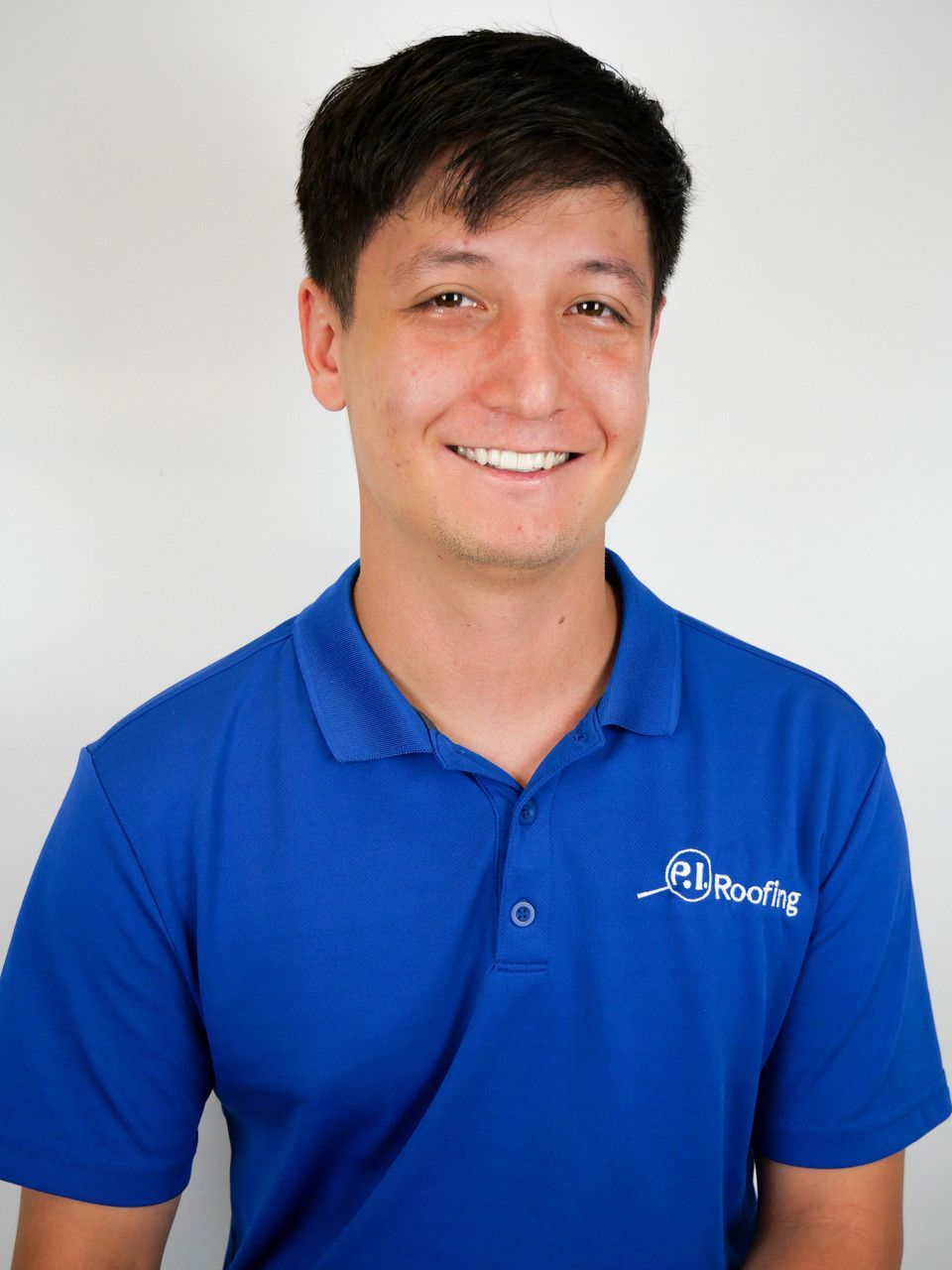 A man wearing a blue polo shirt with the word roofing on it