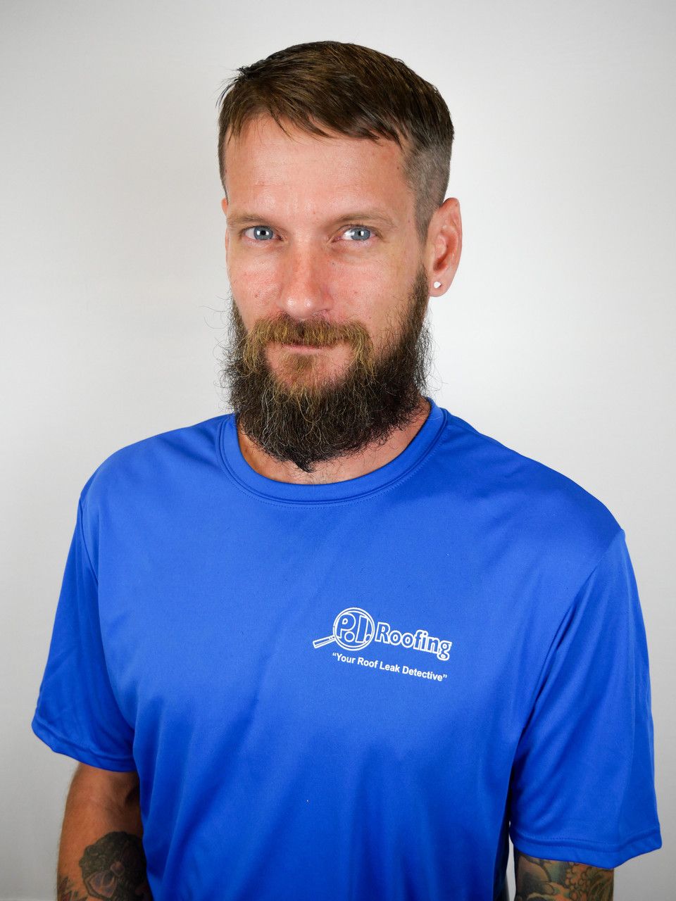 A man with a beard is wearing a blue shirt