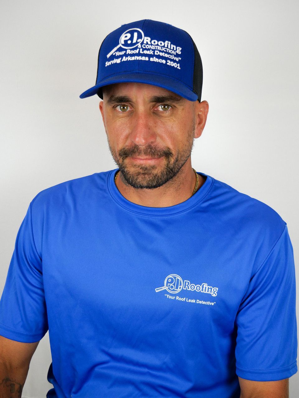 A man wearing a blue shirt and a blue hat with pd roofing written on it