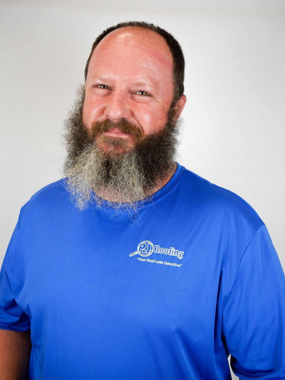 A man with a beard and mustache is wearing a blue shirt.