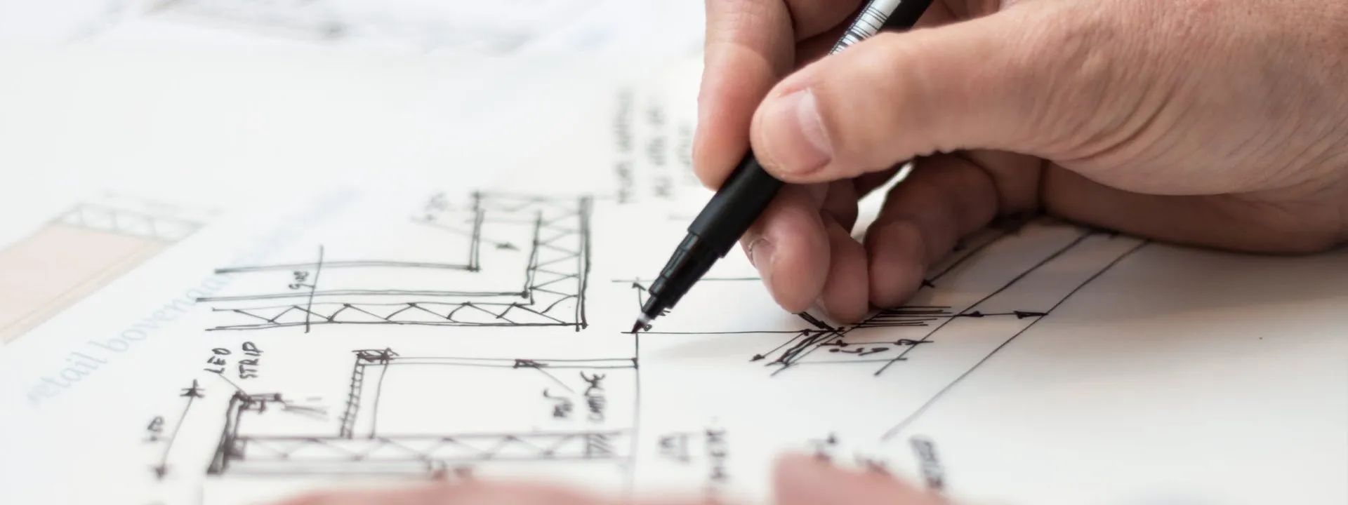 Hand sketching on architectural blueprints.