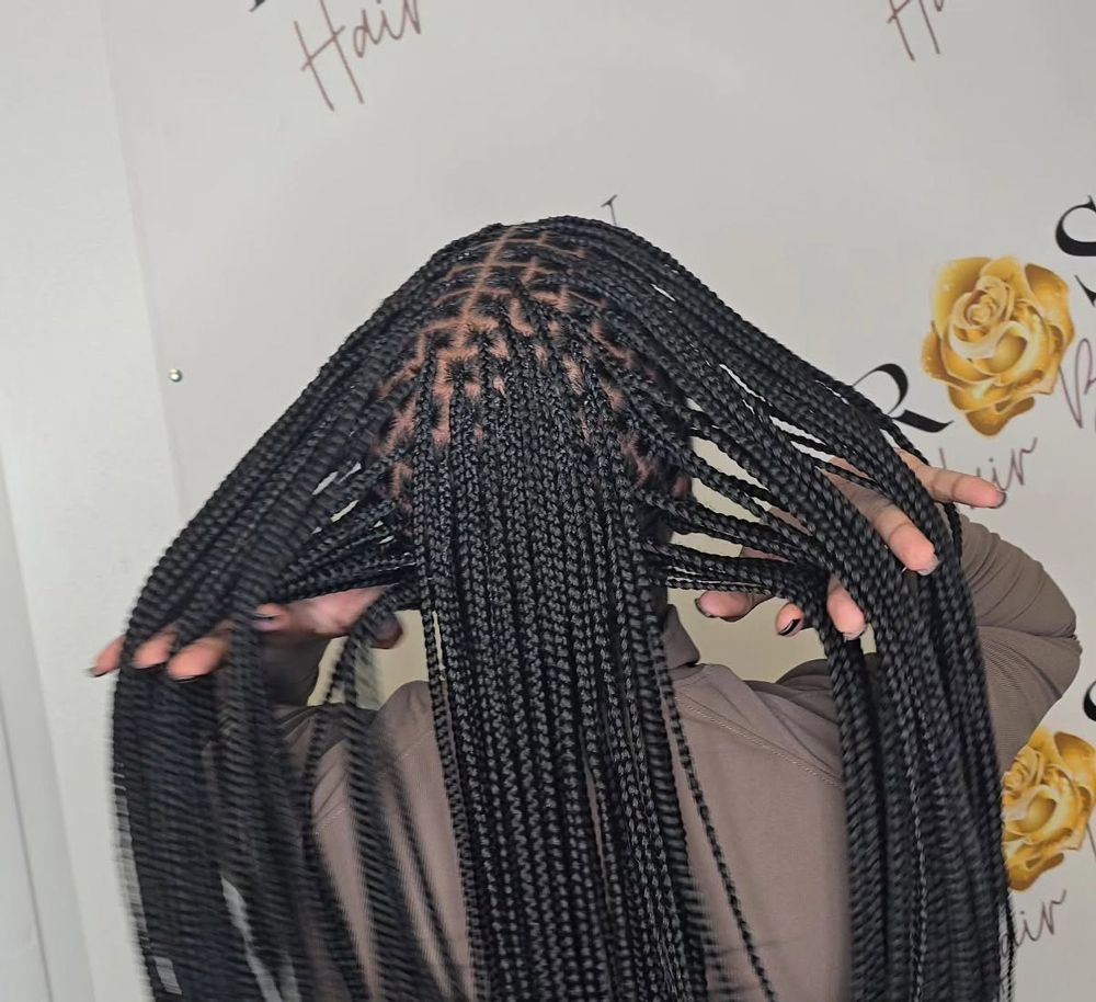 A woman with braids in her hair covering her face