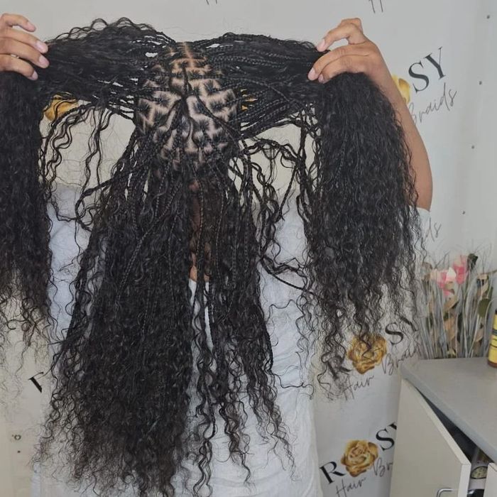 A woman with braids wearing a black face mask
