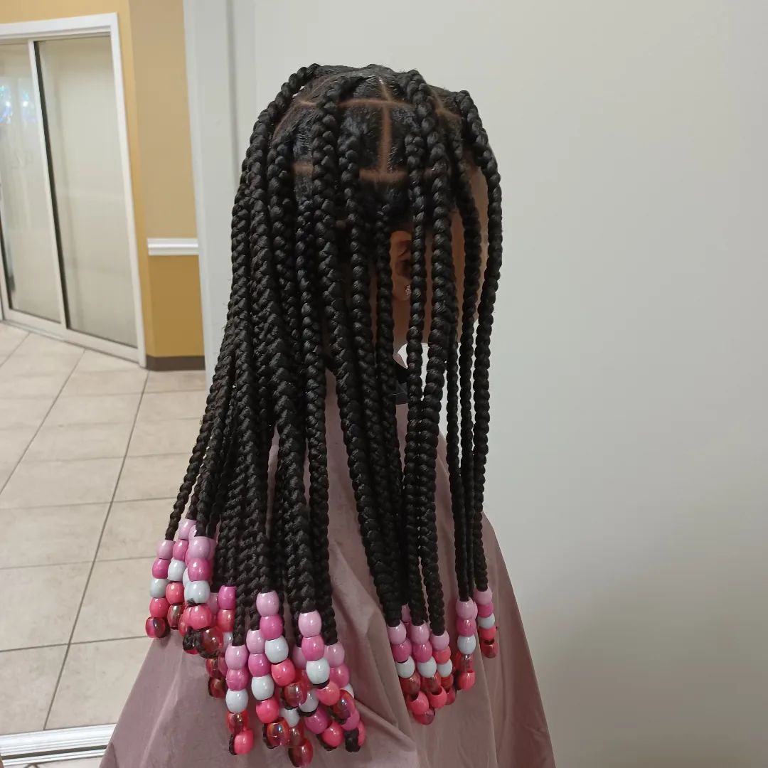 A woman with braids and pink beads in her hair