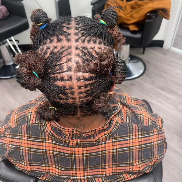 A woman with dreadlocks is sitting in a chair in a salon.