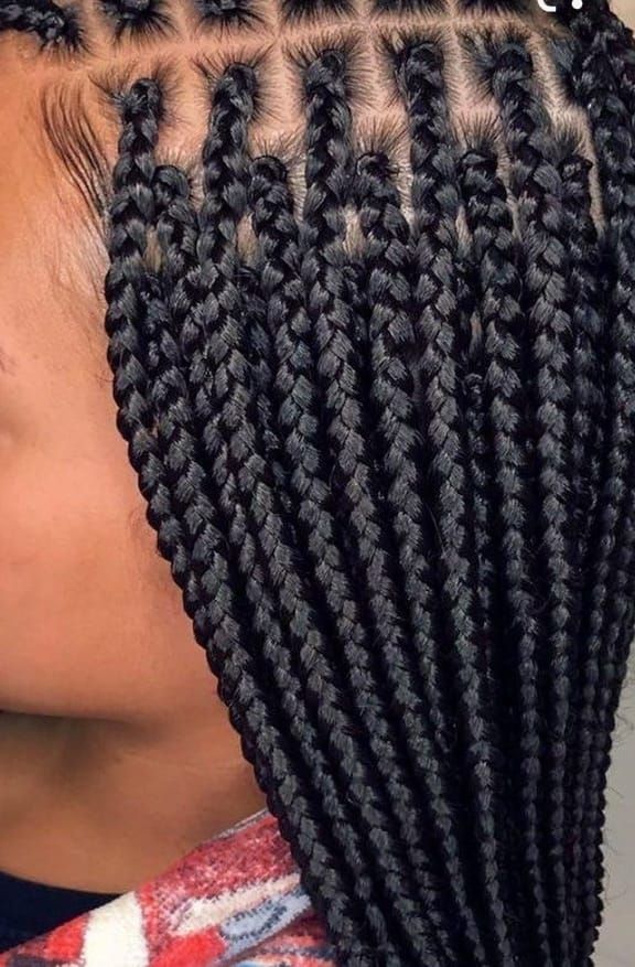 A close up of a woman 's braids on a purple background.