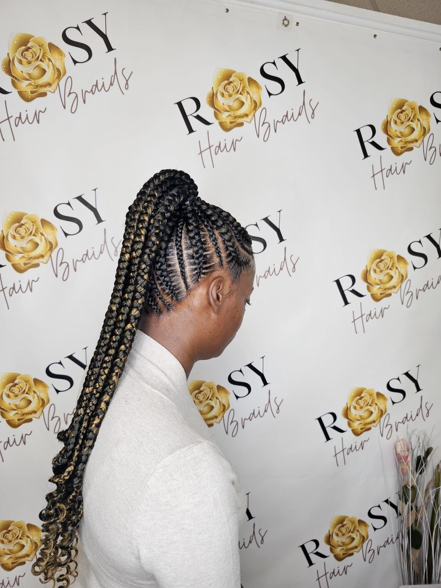 A woman with braids in her hair is sitting in a chair
