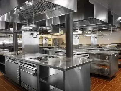 A large commercial kitchen with stainless steel appliances and counter tops.