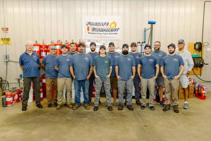 A group of men are posing for a picture in a garage.