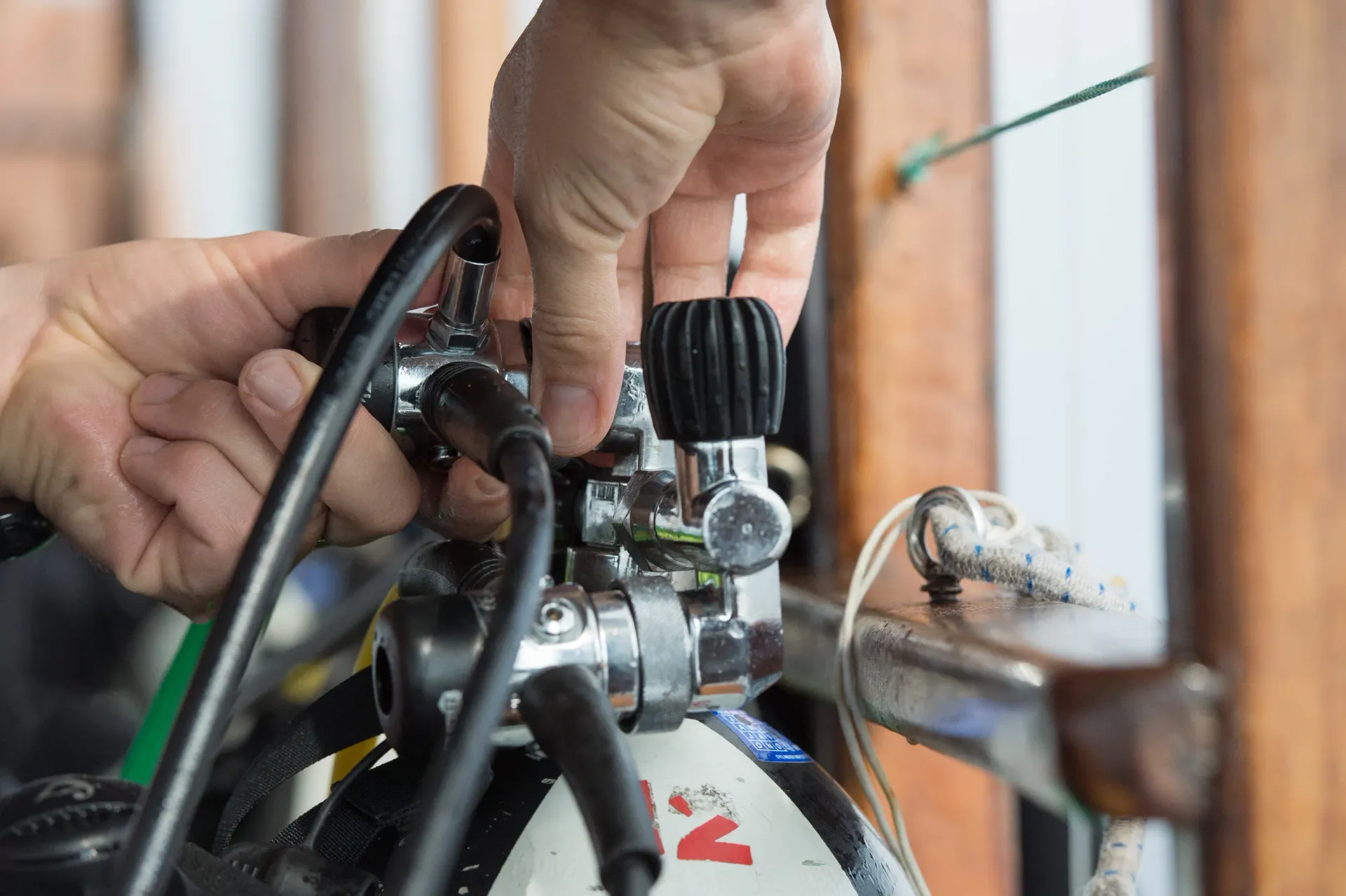 A person is fixing a scuba tank with their hands.