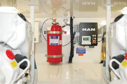 A red fire extinguisher is hanging on a wall next to a man box