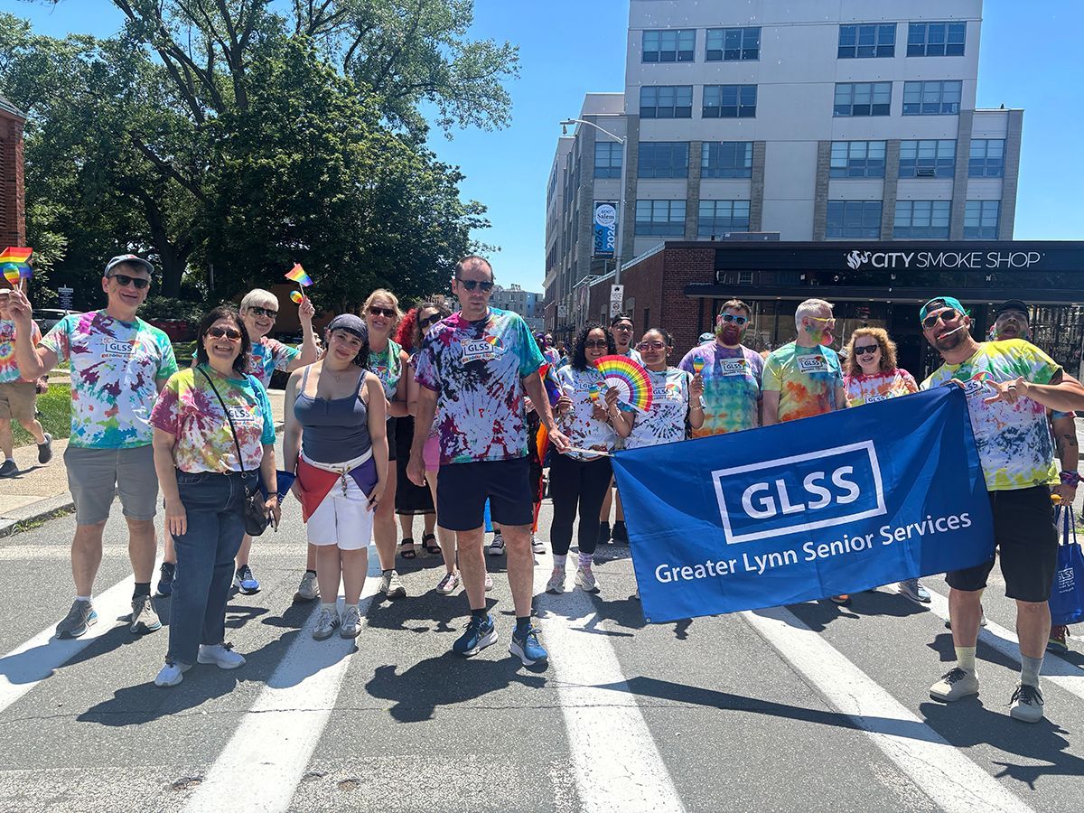 People holding a GLSS Greater Lynn Senior Services banner at a street parade