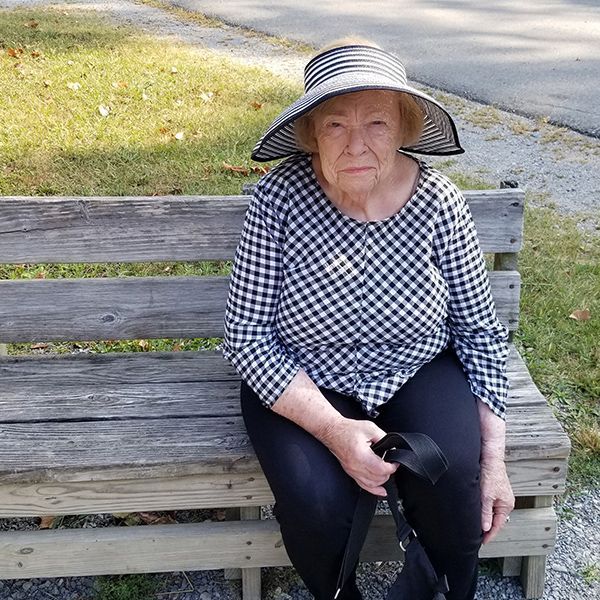 Older woman sitting on a bench outside