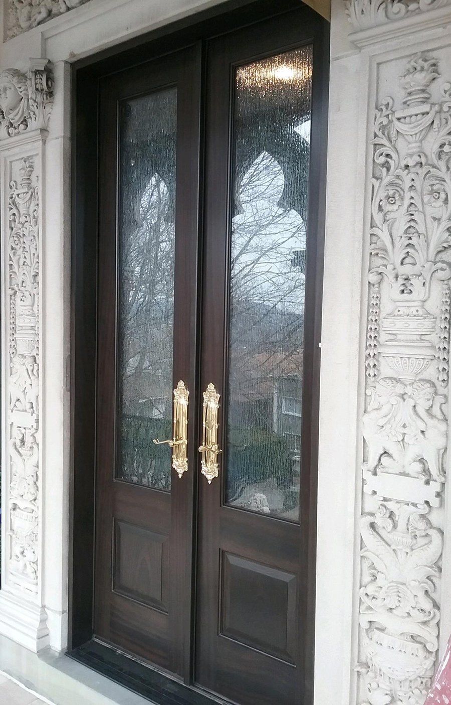 A pair of double doors with gold handles on a building.