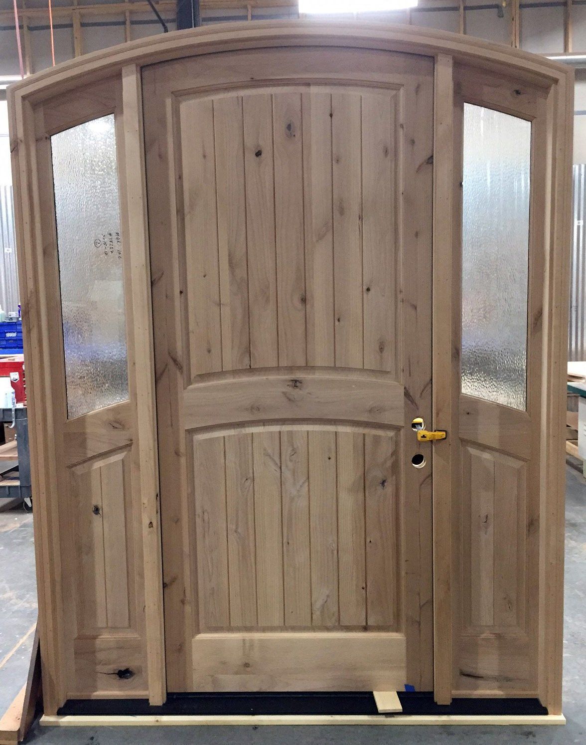 A wooden door with a curved top is being built