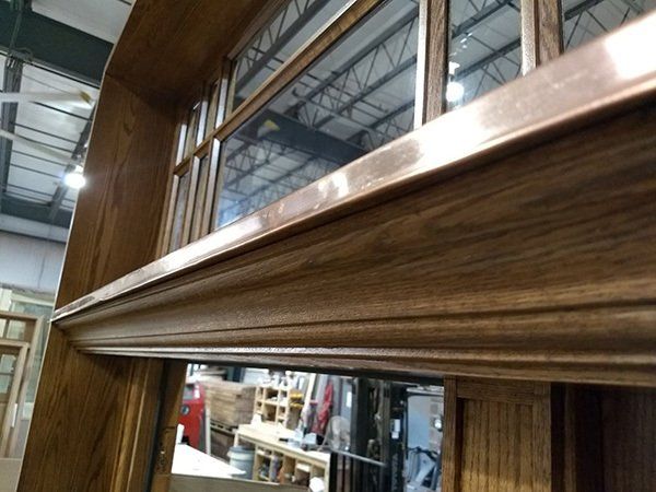 A close up of a wooden window with copper trim
