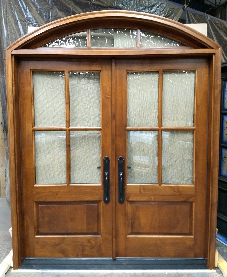 Alder wood double door with arch top transom features flemish style glass