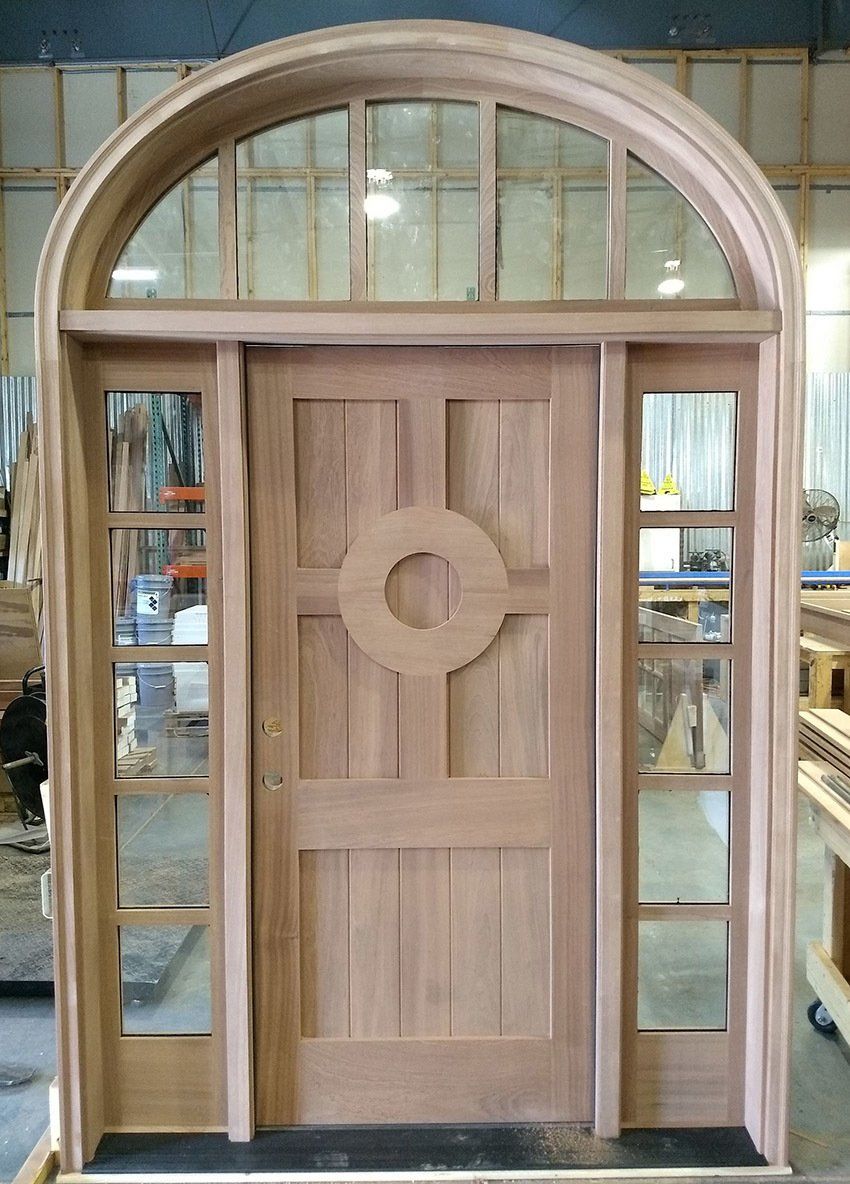 Custom mahogany entry door with sidelites and round top transom features circle cut in top panel
