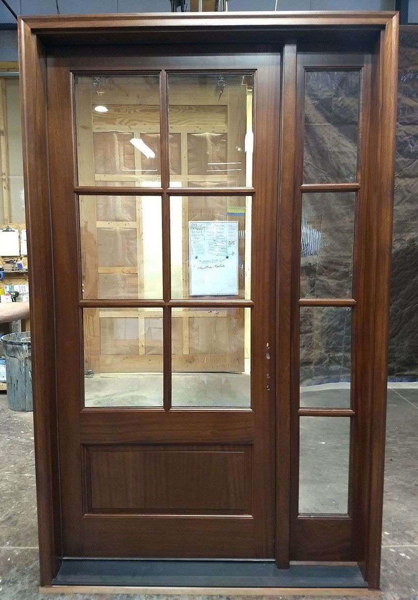 A wooden door with glass panels is sitting on top of a wooden table.