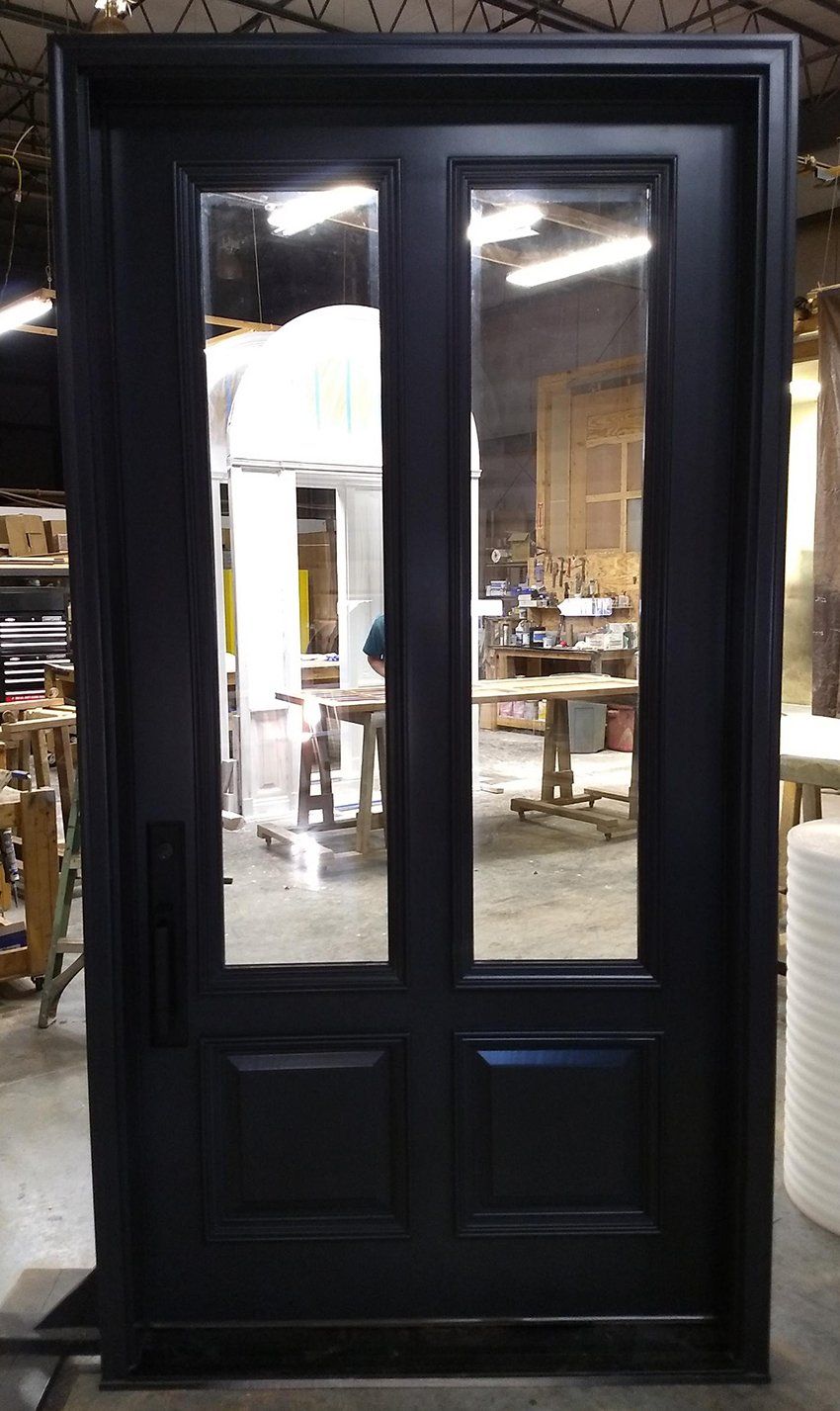 A black door with glass panels is sitting in a warehouse.