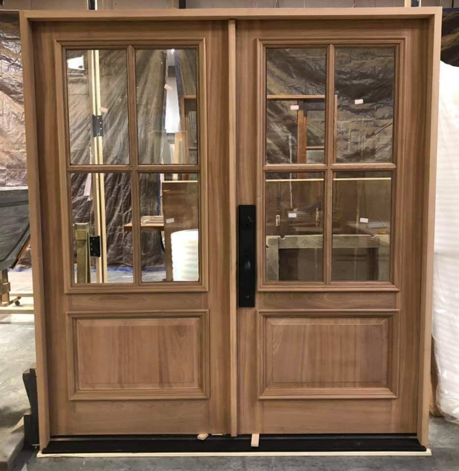 A pair of wooden doors with glass panels are sitting in a room.