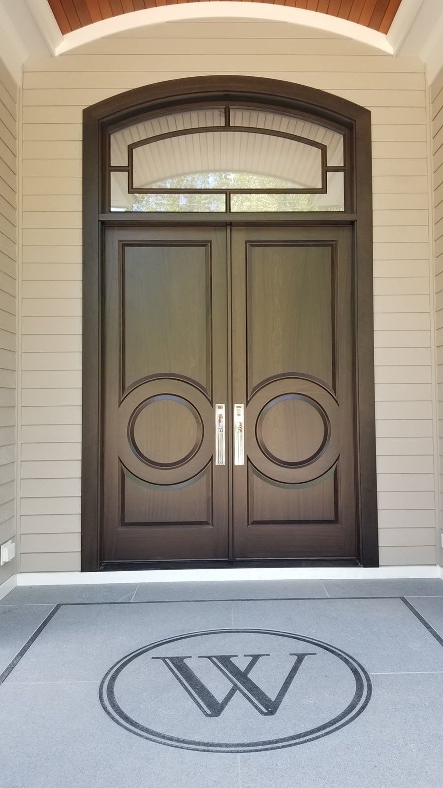 The front door of a house with a monogram on the floor.