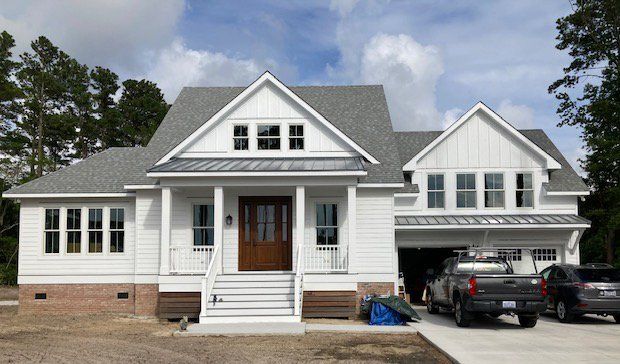 A white house with a truck parked in front of it
