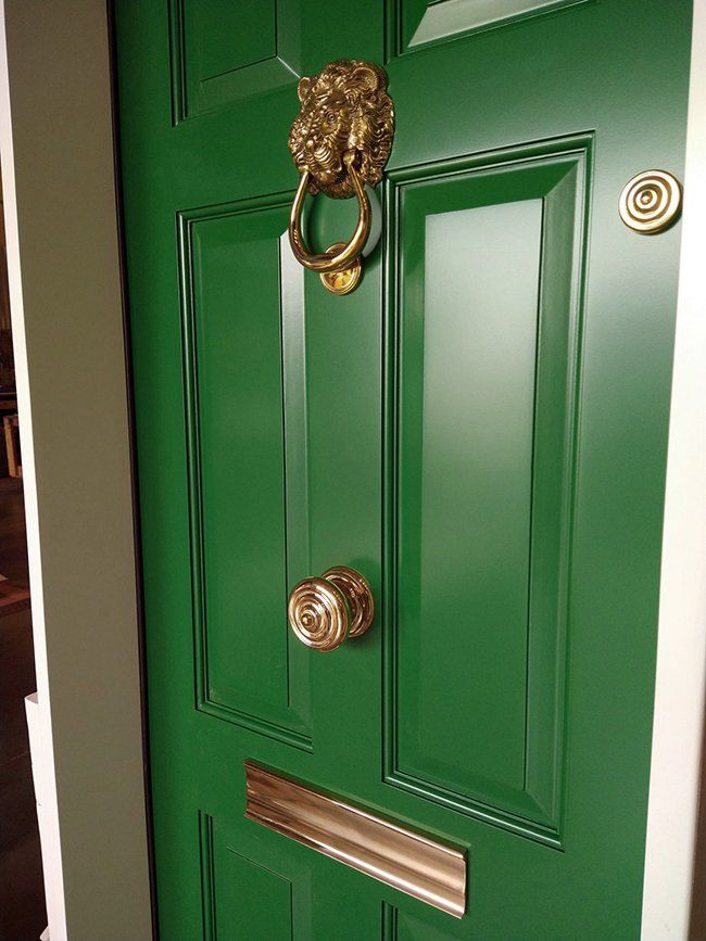 A green door with a lion knocker on it.