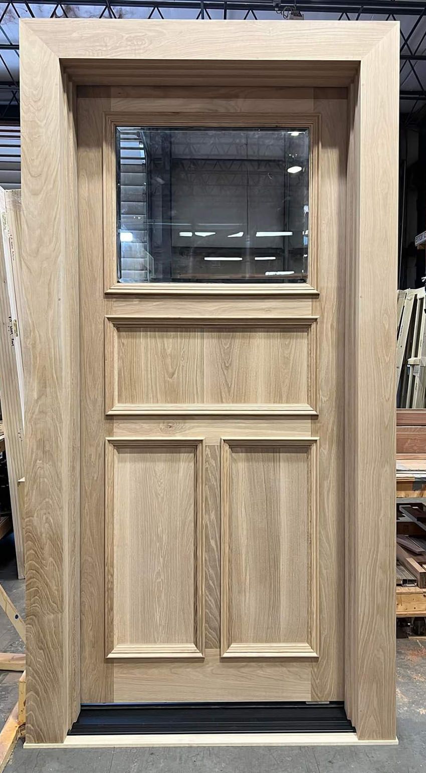 Flat white oak. 42x96x 2 1/4 one lite beveled over one vertical grain horizontal panel, over two vertical panels. Applied moldings both sides.