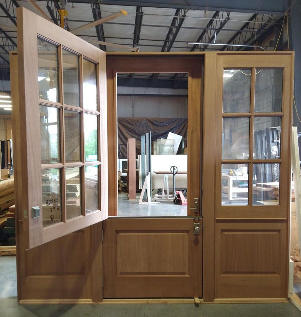 A wooden door with glass panels is open in a warehouse