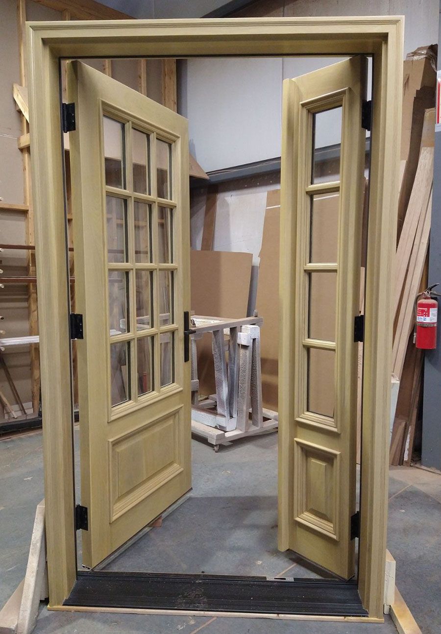A wooden door is open in a warehouse with a fire extinguisher in the background.