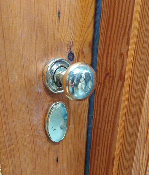 A close up of a door knob on a wooden door.
