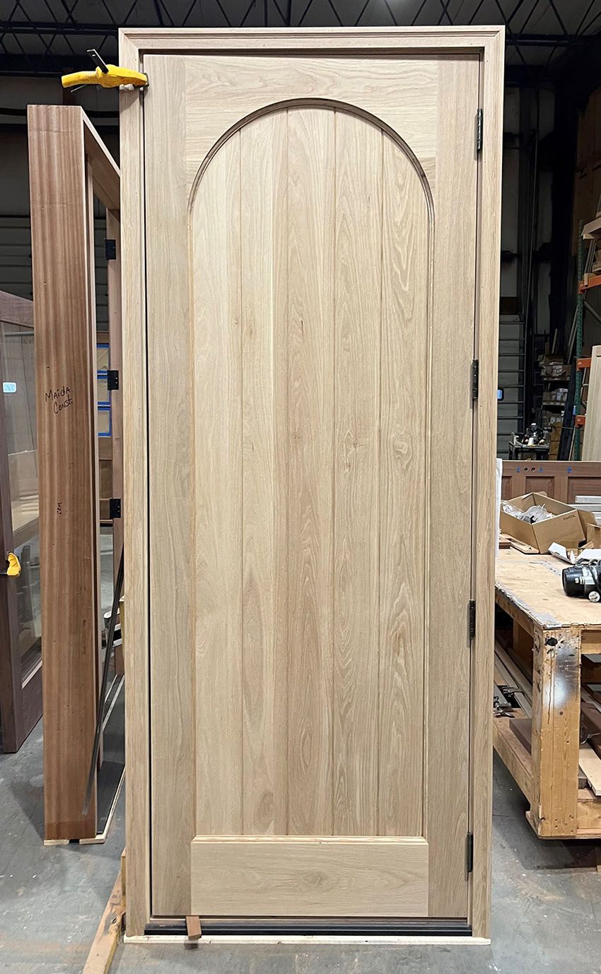 A wooden door is sitting on top of a wooden table in a warehouse.