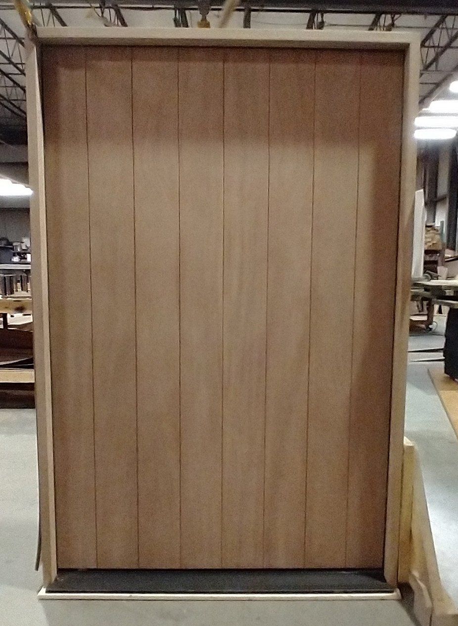 A large wooden door in a box in a factory